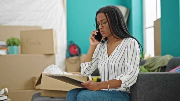 在智能手机上说话的非洲裔美国女人在新家时看起来很沮丧 — 图库视频影像