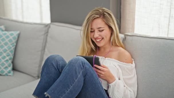 Mujer Rubia Joven Viendo Vídeo Touchpad Sentado Sofá Casa — Vídeos de Stock