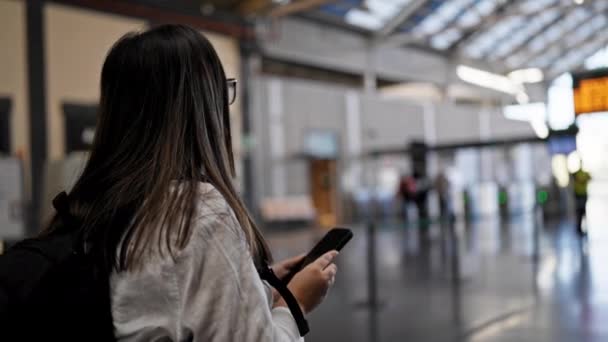 Ung Vacker Latinamerikansk Kvinna Tittar Tågschema Smartphone Tågstationen — Stockvideo