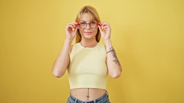 Mladá Blondýnka Žena Úsměvem Jistota Vytahování Brýle Přes Izolované Žluté — Stock video