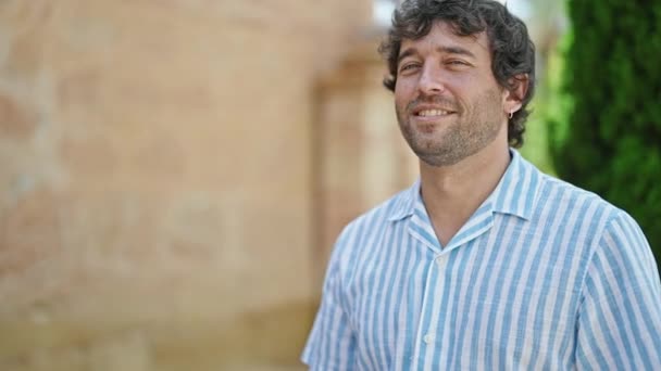 Молодий Іспаномовний Чоловік Посміхається Впевнено Стоячи Зброєю Перетнув Жест Вулиці — стокове відео