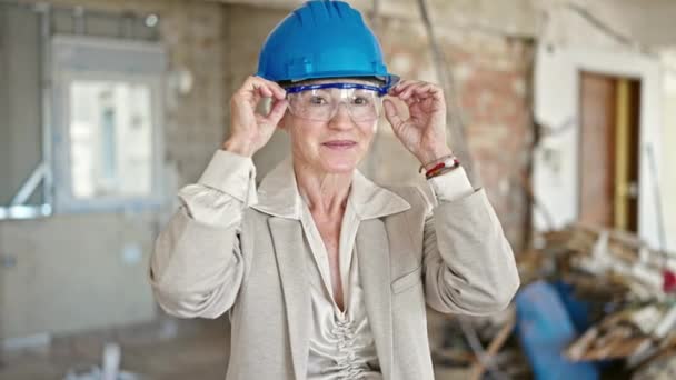 中年金发女建筑师自信地笑着在建筑工地拿出眼镜 — 图库视频影像