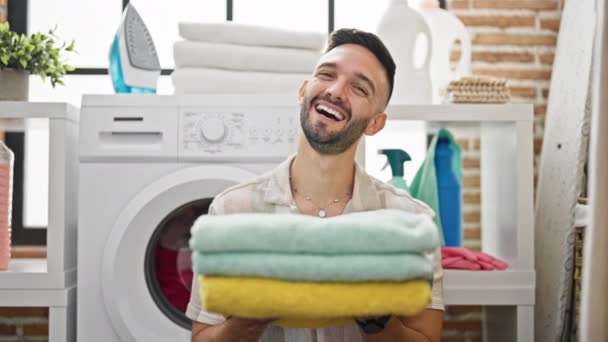 Νεαρός Ισπανός Που Κρατάει Καθαρές Διπλωμένες Πετσέτες Χαμογελώντας Στο Πλυσταριό — Αρχείο Βίντεο