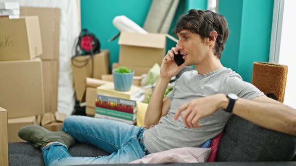 Genç Spanyol Adam Akıllı Telefondan Konuşuyor Yeni Evindeki Kanepede Oturuyor — Stok video