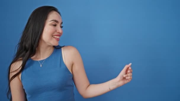 Młoda Piękna Latynoska Uśmiechnięta Kobieta Wskazująca Bok Palcem Odizolowanym Niebieskim — Wideo stockowe