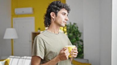 Genç İspanyol adam evde kahve içiyor.