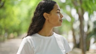 Afro-Amerikalı kadın parkta kendinden emin bir şekilde gülümsüyor.