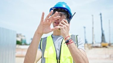 Genç İspanyol mimar inşaat alanında telsizle konuşuyor.