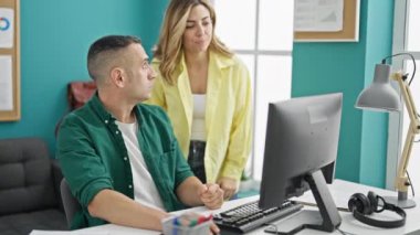 Kadın ve erkek işçiler ofiste çalışan bilgisayarları kullanıyorlar.