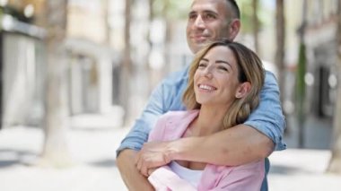 Man and woman couple hugging each other kissing at street