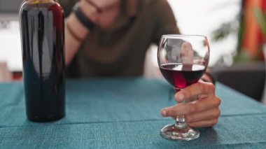 Kafası yemek odasında depresif bir vaziyette bir kadeh şarap tutan İspanyol genç adam.