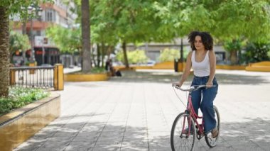 Genç ve güzel İspanyol kadın bisikletini park bankında otururken durdurdu.
