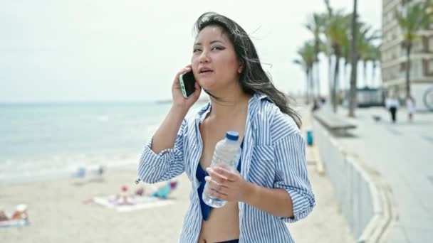 Молодая Китаянка Туристка Разговаривает Смартфону Бутылкой Воды Берегу Моря — стоковое видео