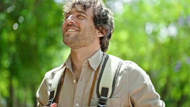 Νεαρός Ισπανός Τουρίστας Φοράει Σακίδιο Χαμογελώντας Στο Πάρκο — Αρχείο Βίντεο