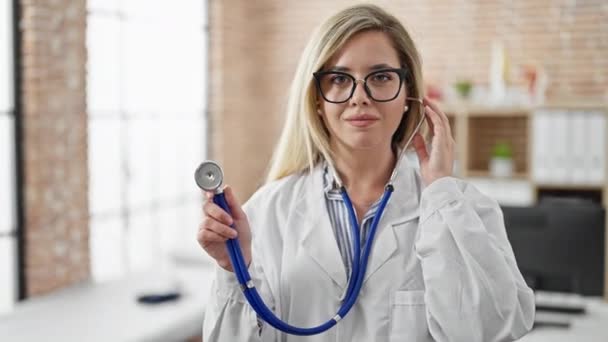 Jeune Femme Blonde Médecin Souriant Confiant Tenant Stéthoscope Clinique — Video