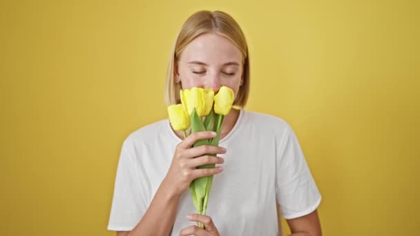 Junge Blonde Frau Die Blumen Riecht Lächelt Über Isolierten Gelben — Stockvideo