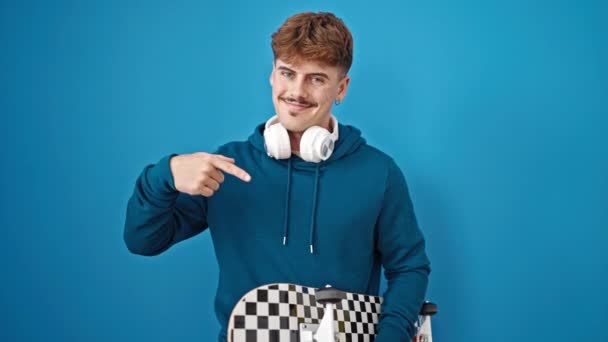 Молодий Іспаномовний Чоловік Який Вказує Ковзання Навушниках Над Ізольованим Синім — стокове відео