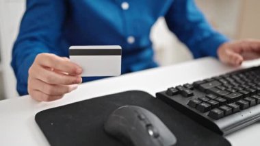 Ofiste bilgisayar ve kredi kartı kullanan İspanyol bir iş adamı.