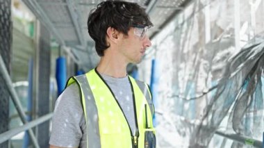 İspanyol asıllı genç bir mimar inşaat alanında ciddi bir yüzle duruyor.