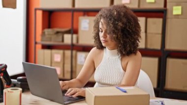 Young beautiful hispanic woman ecommerce business worker using laptop working at office