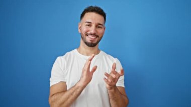 Genç Arap adam gülümsüyor. Kendinden emin el çırpıyor.