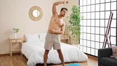 Genç İspanyol adam yatak odasında ısınmaya çalışıyor.