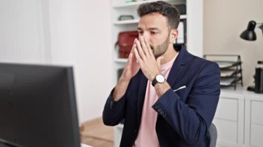Genç İspanyol iş adamı ofiste bilgisayar kullanıyor.