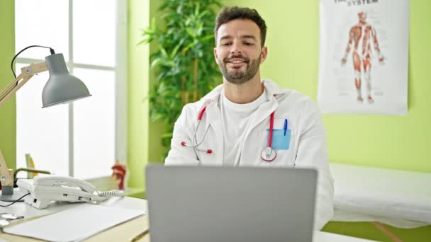 Jovem Hispânico Homem Médico Usando Laptop Trabalhando Com Gesto Vencedor — Vídeo de Stock
