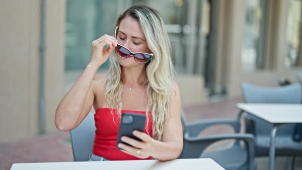 Mujer Rubia Joven Usando Smartphone Quitándose Las Gafas Terraza Cafetería — Vídeos de Stock