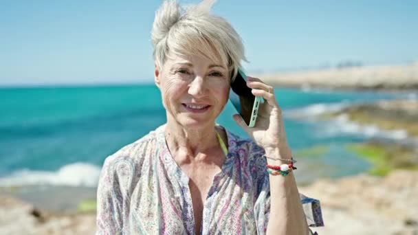 Mulher Loira Meia Idade Turista Sorrindo Confiante Falando Smartphone Praia — Vídeo de Stock