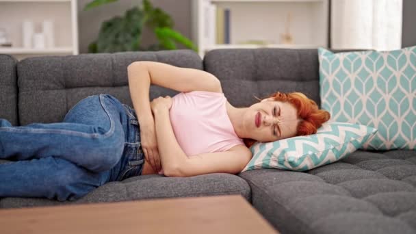 Jovem Ruiva Sofrendo Por Dor Menstrual Deitada Sofá Casa — Vídeo de Stock