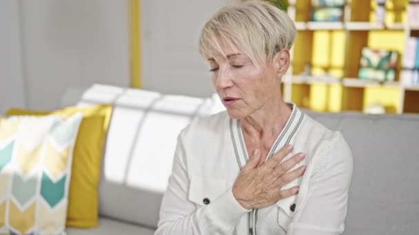 Kanepede Oturan Orta Yaşlı Sarışın Kadın Evinde Kalp Krizi Geçiriyor — Stok video