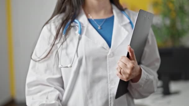 年轻美丽的惊慌失措的女医生手握乳癌意识粉红丝带和剪贴板在诊所 — 图库视频影像