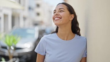 Afro-Amerikalı kadın gülümsüyor. Kendine güveniyor. Gökyüzüne bakıyor.