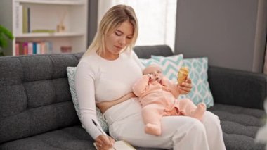 Anne ve kızı evde oturup kruvasan yerken not alıyorlar.