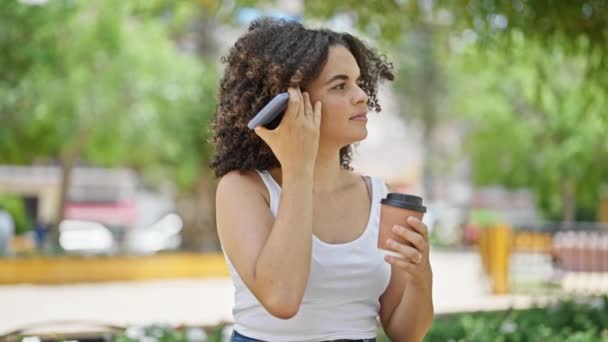 若い美しいヒスパニック系女性が公園でコーヒーを飲むスマートフォンで音声メッセージを送信 — ストック動画