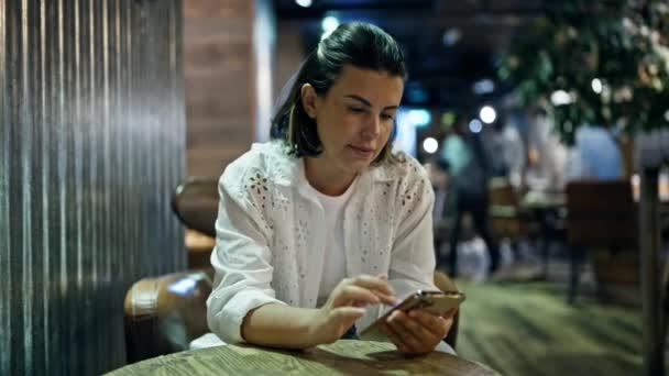 Όμορφη Νεαρή Ισπανίδα Γυναίκα Που Χρησιμοποιεί Smartphone Χαμογελώντας Στην Καφετέρια — Αρχείο Βίντεο