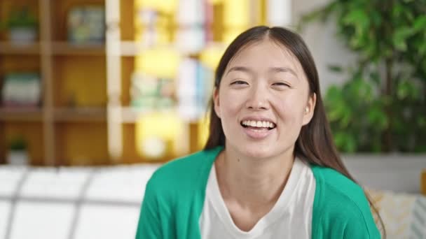 Młoda Chinka Uśmiechnięta Pewnie Siedzi Kanapie Domu — Wideo stockowe