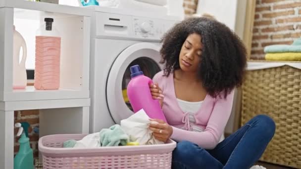 Mujer Afroamericana Lavando Ropa Sosteniendo Botella Detergente Con Expresión Triste — Vídeos de Stock