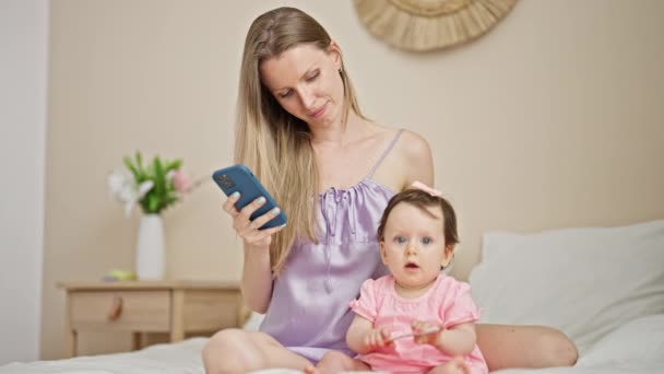 Μητέρα Και Κόρη Χρησιμοποιώντας Smartphone Κάθεται Στο Κρεβάτι Φιλιά Στο — Αρχείο Βίντεο