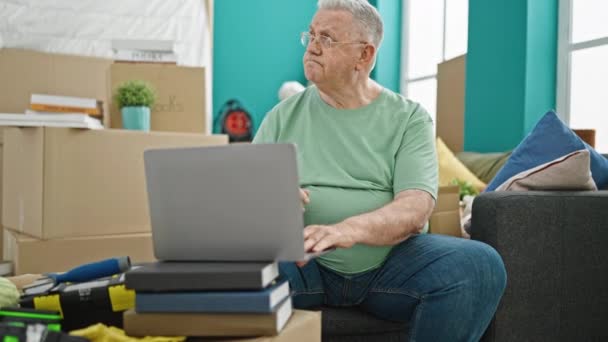 Hombre Pelo Gris Mediana Edad Usando Portátil Sentado Sofá Pensando — Vídeo de stock