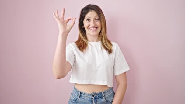 Mujer Rubia Joven Haciendo Buen Gesto Sonriendo Sobre Fondo Rosa — Vídeo de stock