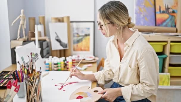 在艺术工作室 年轻的金发女画家在纸上画画 摘下眼镜累了 — 图库视频影像