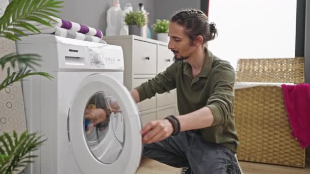 年轻的惊慌失措的男人在洗衣房里洗衣服 — 图库视频影像