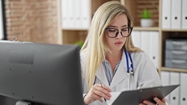 Jovem Loira Médico Usando Computador Leitura Relatório Médico Clínica — Vídeo de Stock