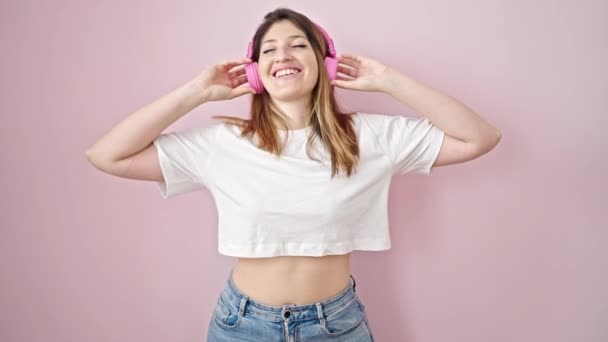 Молодая Блондинка Слушает Музыку Танцует Изолированном Розовом Фоне — стоковое видео