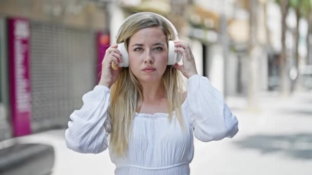 Mujer Rubia Joven Quitándose Los Auriculares Diciendo Que Con Cabeza — Vídeos de Stock