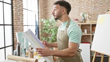 Sanat atölyesinde duvara resim çizen genç bir Arap sanatçı.