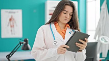 Genç, güzel İspanyol kadın doktor klinikte dokunmatik ped kullanıyor.