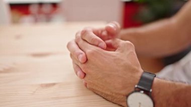 Genç İspanyol adam yemek odasında gergin hareketlerle masaya dokunuyor.